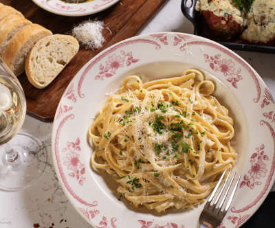 fettuccine pasta & full table of delicious food